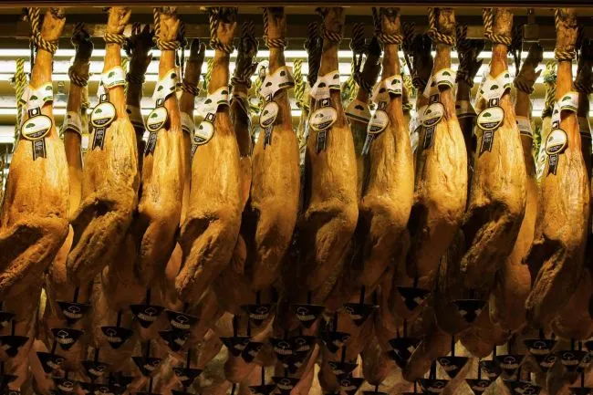 Several full Iberian bellota ham legs hanging